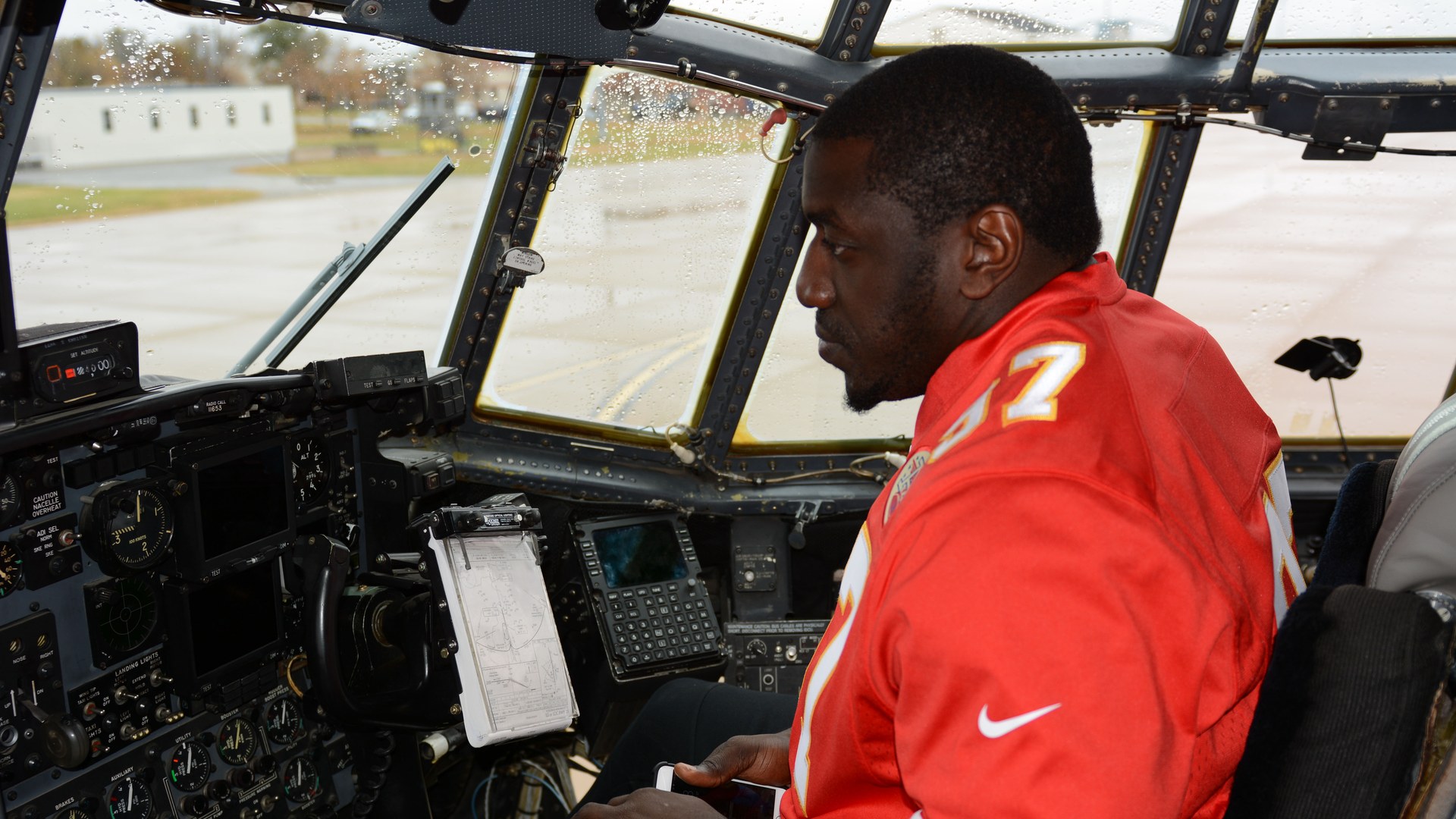 Allen Bailey seated in an aircraft cockpit during a Chiefs visit to Rosecrans Air National Guard Base