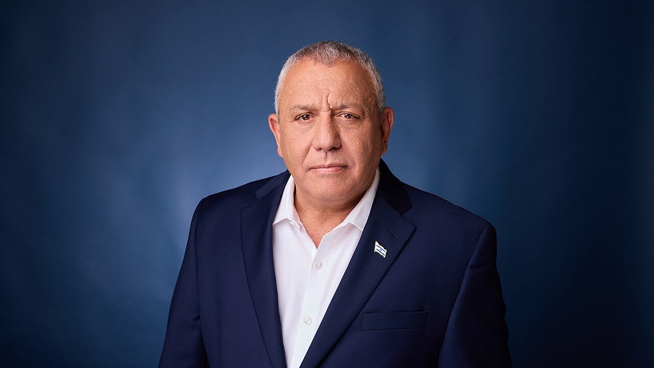 Portrait of Gadi Eisenkot, leader of the Yashar party, wearing a navy suit and an Israel flag pin