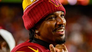 Jayden Daniels smiles on the Washington sideline