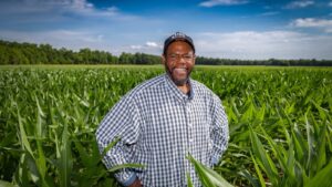 Jamie Davis standing in a green cornfield in Tensas Parish Louisiana