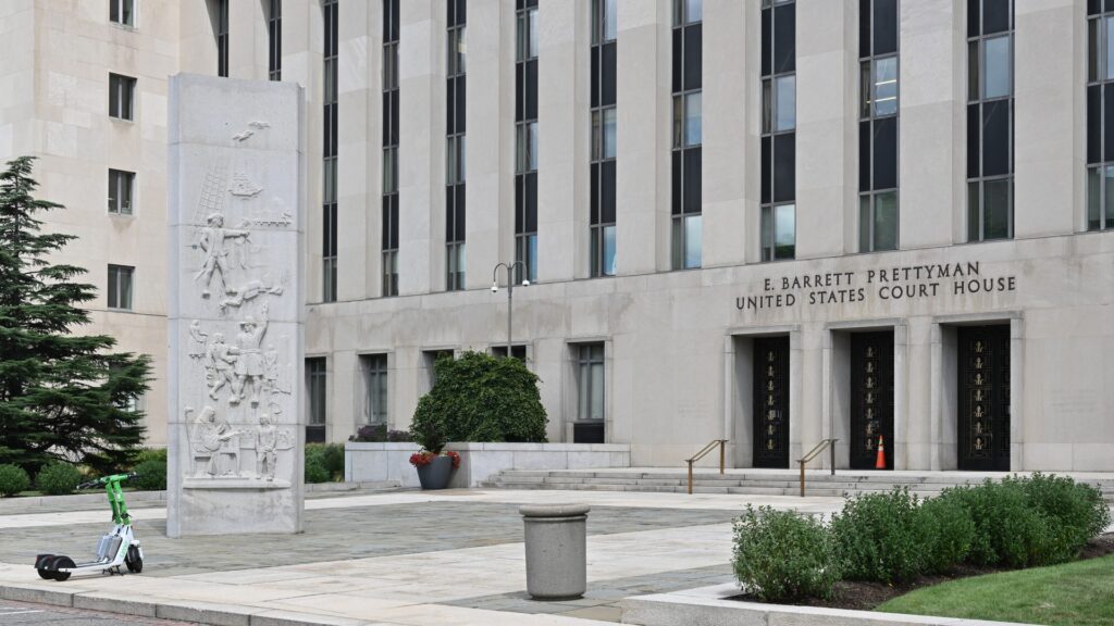The front of the Prettyman United States Courthouse in Washington with flags above the entrance