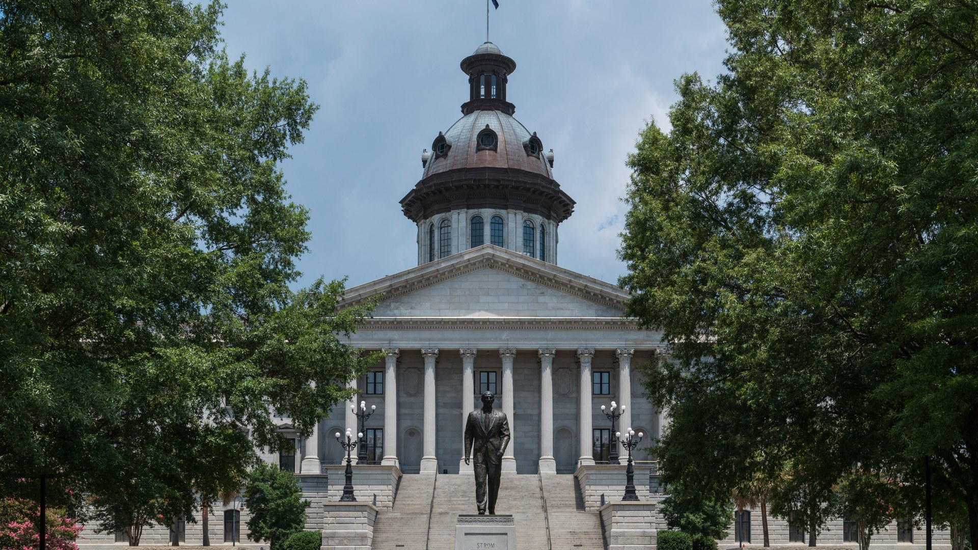 The South Carolina State House in Columbia framed by trees under a blue sky