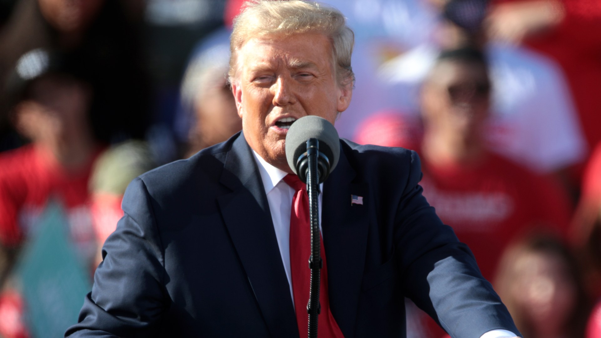 President Donald Trump speaks into a microphone at a campaign rally