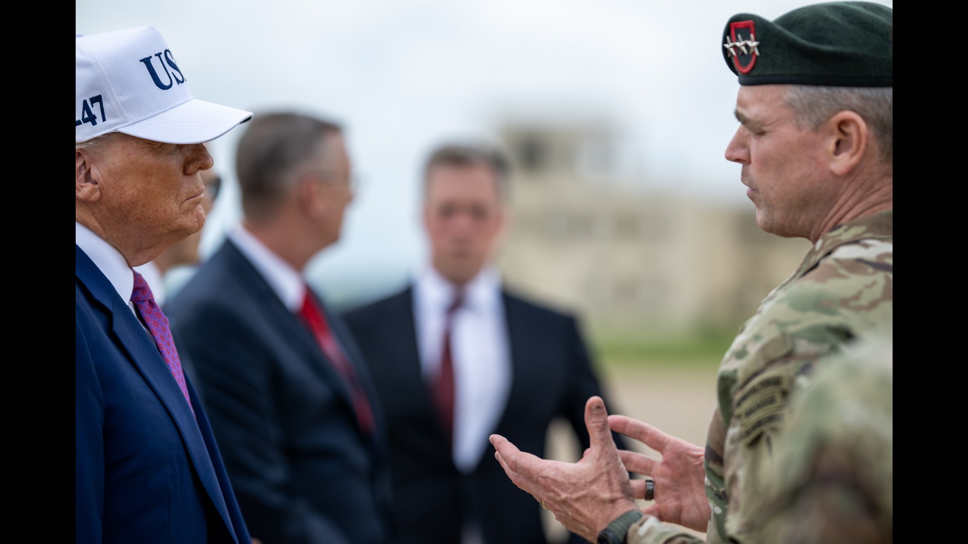President Donald Trump in a white cap at Fort Bragg
