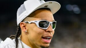 Christian Watson in a Green Bay Packers cap and sunglasses in a close up file photo