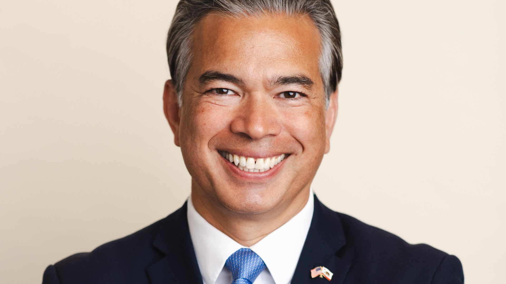 California Attorney General Rob Bonta smiling in a suit and blue tie in his official portrait