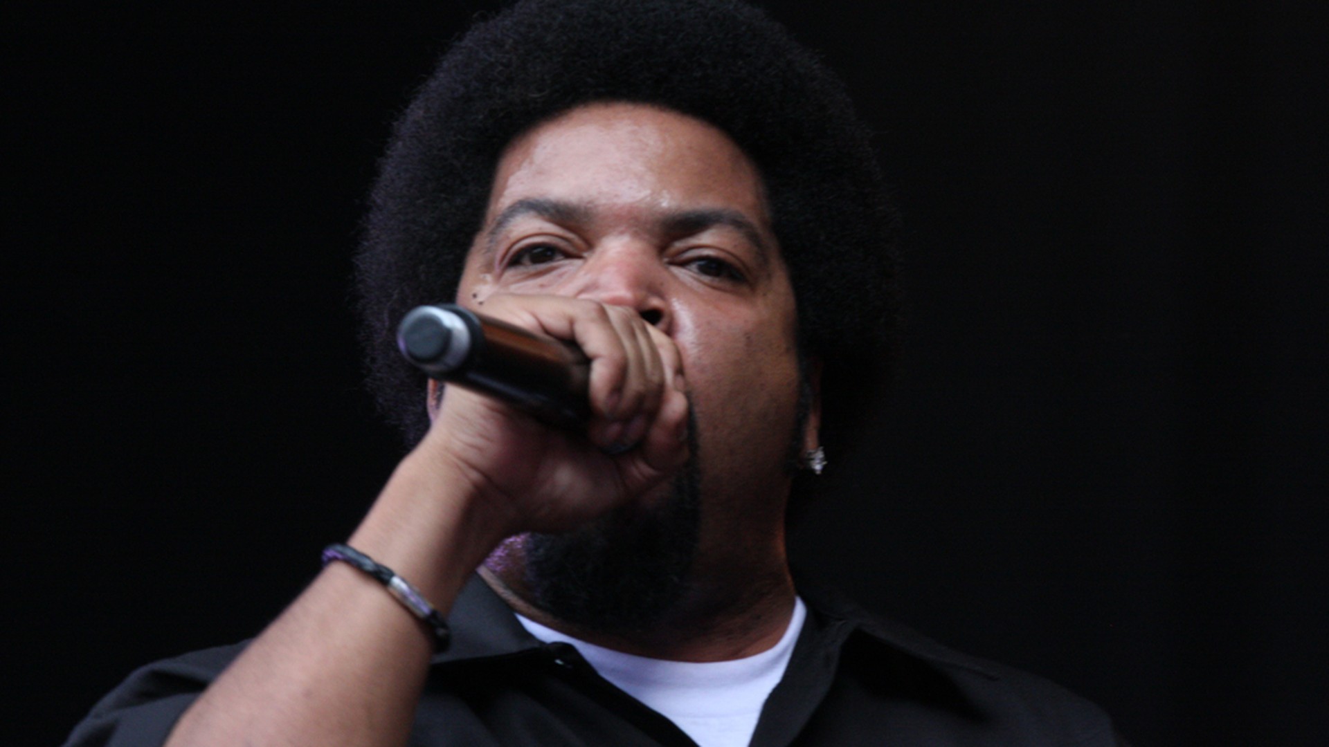 Ice Cube raps into a microphone in a close stage view
