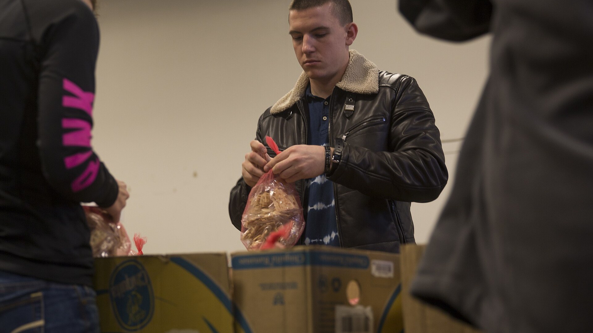 A volunteer packs food at a food bank warehouse