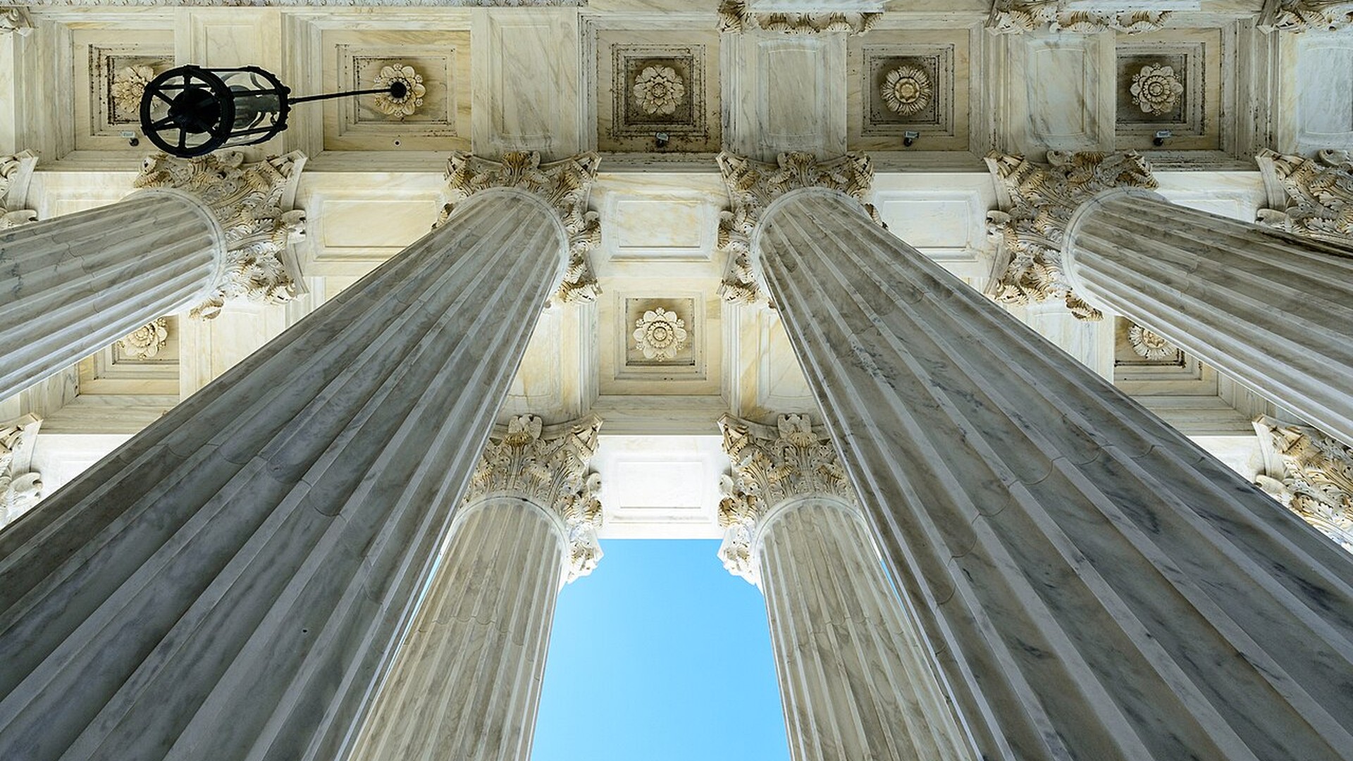Marble columns of the United States Supreme Court building seen from below