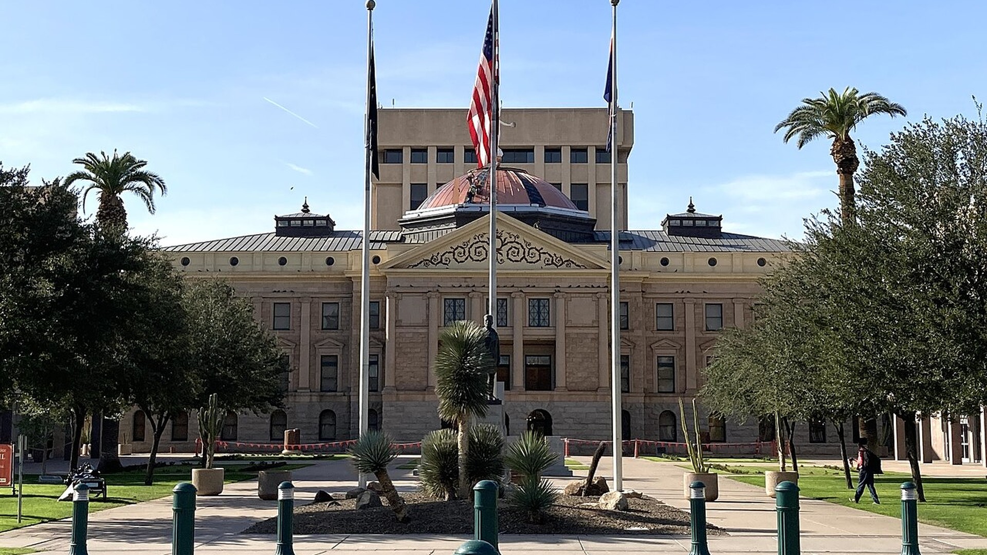 The Arizona State Capitol building in Phoenix with flags and palm trees