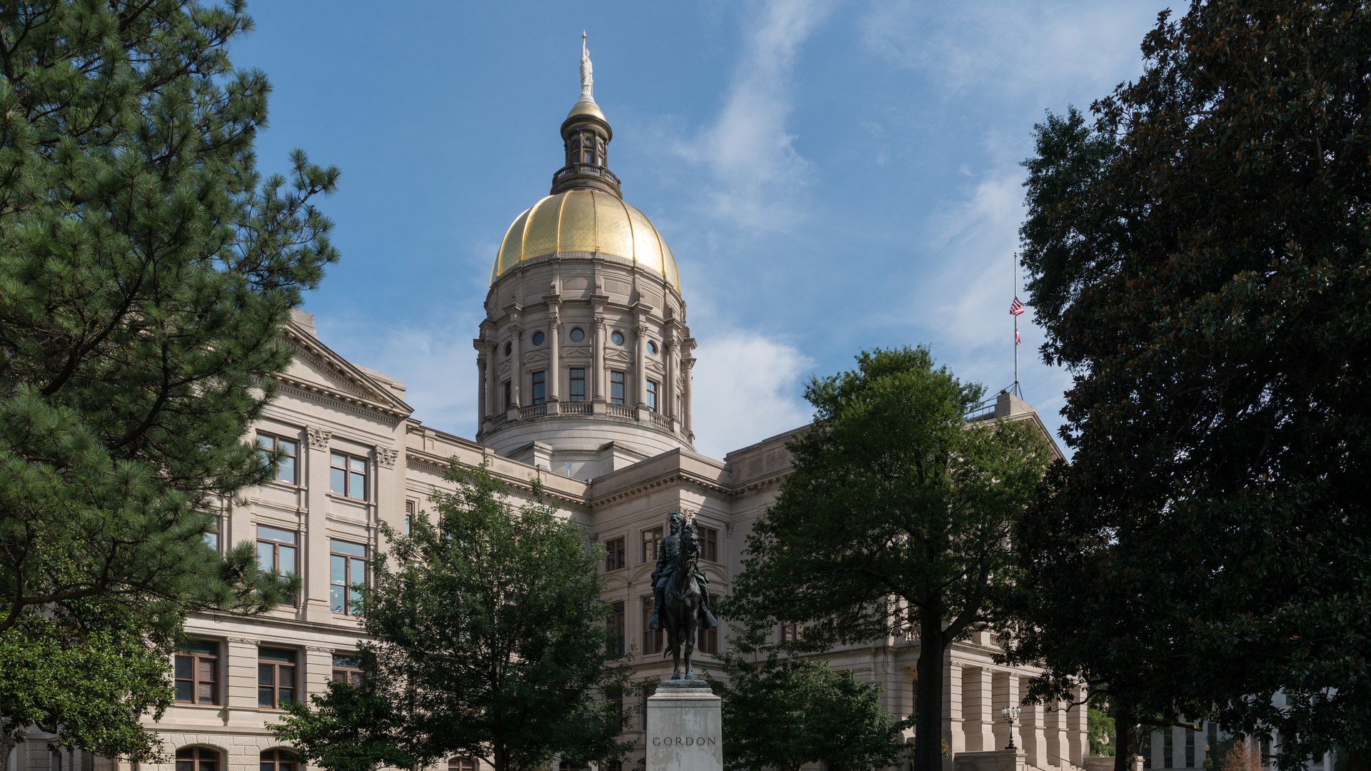 Georgia State Capitol gold dome above trees in Atlanta