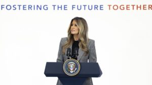 First Lady Melania Trump speaking at a podium during the Fostering the Future Together summit
