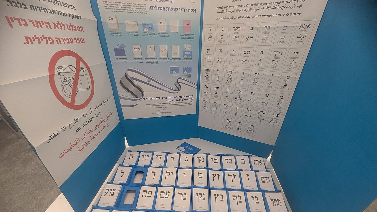 Ballot slips for Israeli political parties arranged inside a voting booth at a polling station