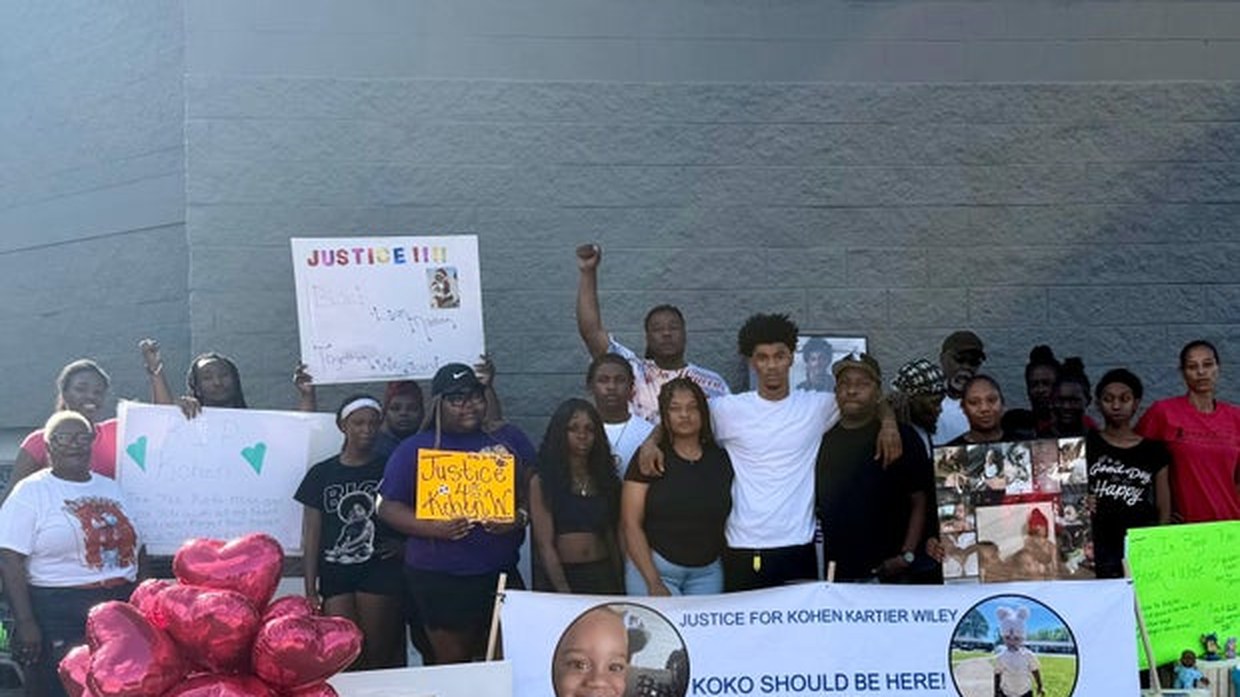 Family and supporters hold a banner reading Justice for Kohen Kartier Wiley at a gathering for Kohen