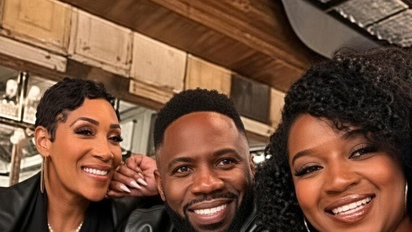 Pastor Lydia Ford, Prophet Israel Ford, and Minister Shakayla Ford smile together at a table
