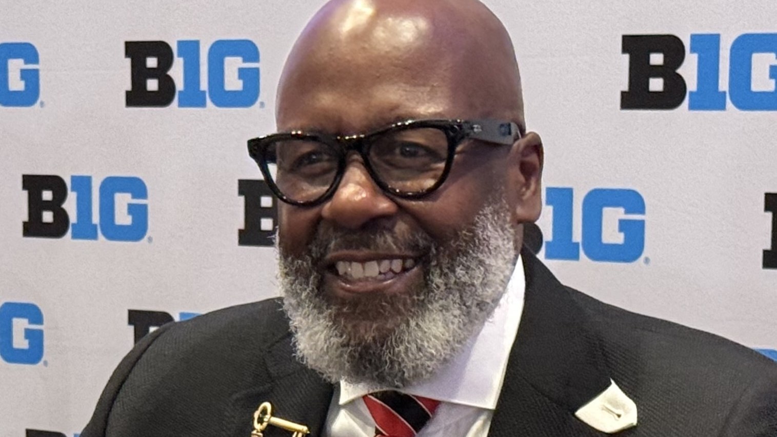 Mike Locksley smiles while speaking with reporters at Big Ten Media Days