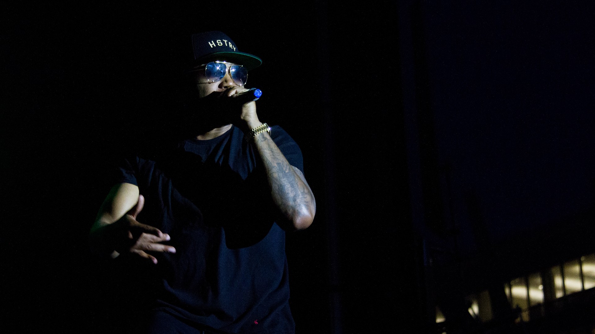 Nas performing live on stage holding a microphone