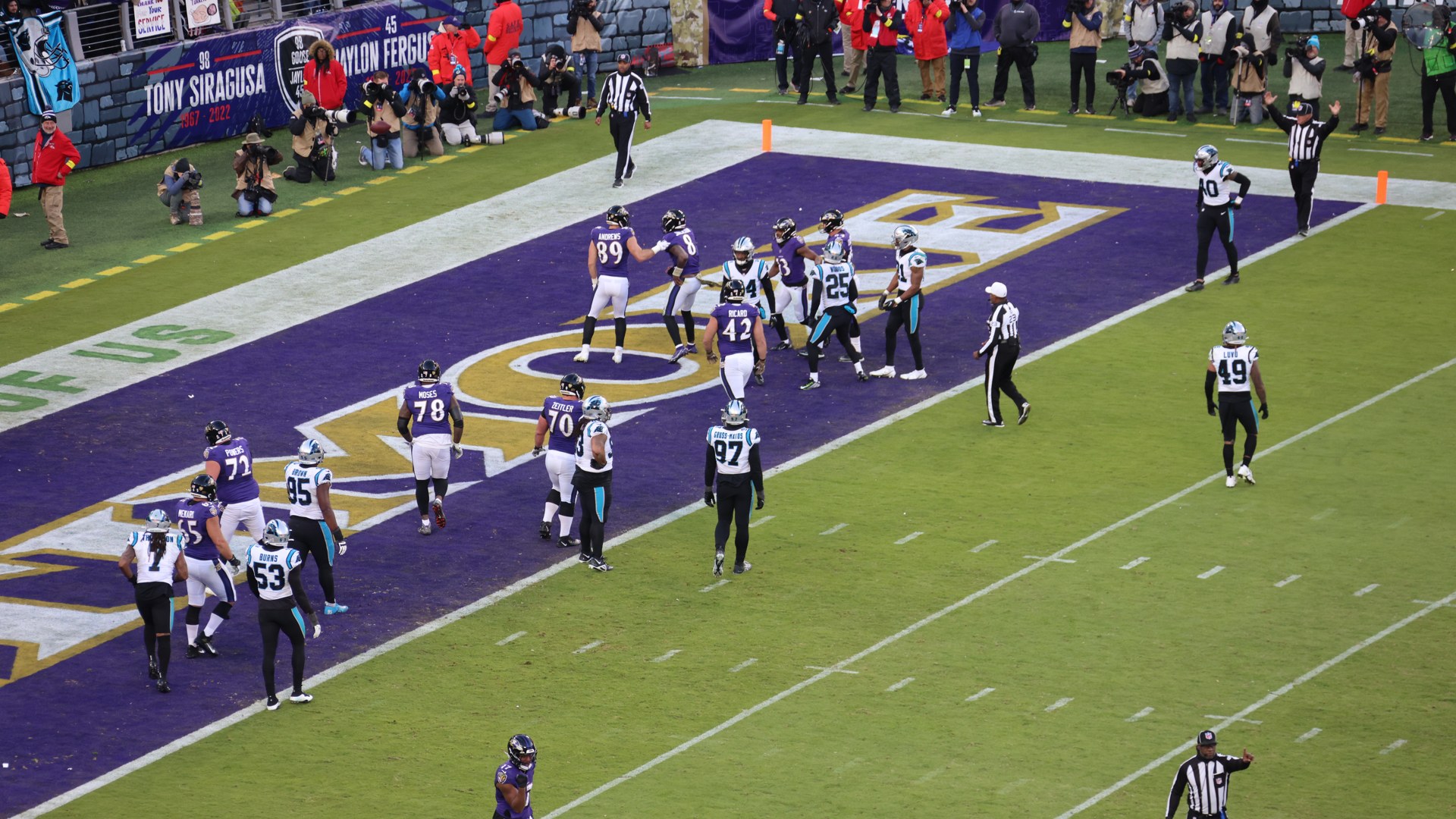 Baltimore Ravens players standing in the end zone at their home stadium