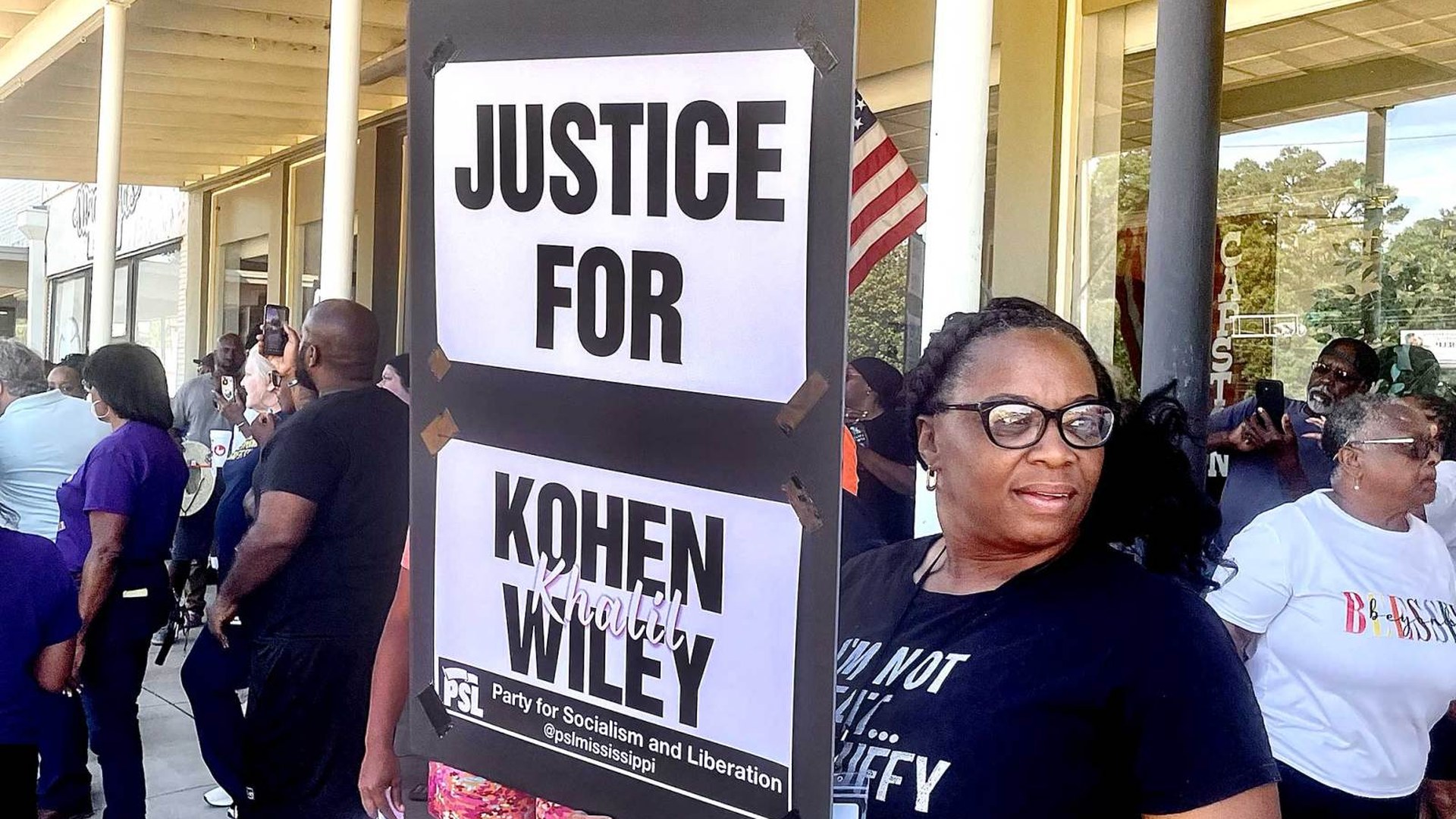 A protester holds a sign reading Justice for Kohen Wiley at a rally in Senatobia