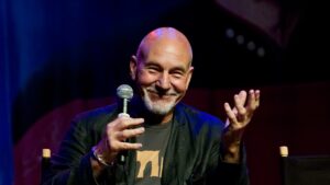Patrick Stewart smiling while speaking into a microphone at a Star Trek convention in 2011
