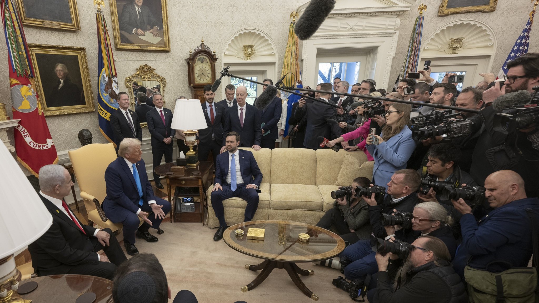 President Donald Trump and Prime Minister Benjamin Netanyahu seated in the Oval Office surrounded by press photographers